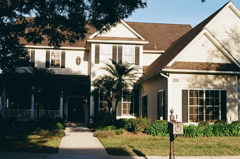 Two-story home with covered porch and manicured lawn — the kind of staged curb appeal that drives MLS listing click-through